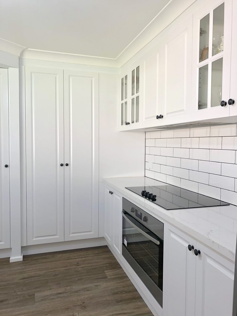 Gorgeous white polyurethane cabinets wth 3 door pantry and timber floors - kitchen renovation by Master Bathrooms & Kitchens