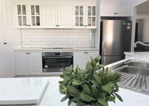 Stunning white raised panel cabinet doors with Caesarstone benchtops & subway tile - kitchen renovation by Master Bathrooms & Kitchens
