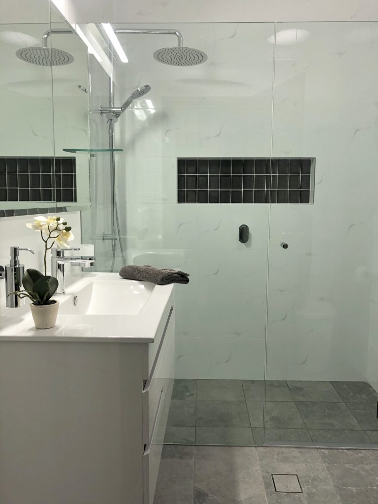  Beautiful hobless shower with linear shower drain, niche and frameless shower screen creating the appearance of space - bathroom renovation by Master Bathrooms & Kitchens.