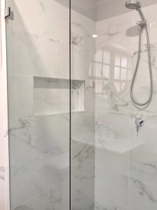 Corner shower recess with hand held shower rose, mixer, niche and frameless shower screen - bathroom renovation by Master Bathrooms & Kitchens.